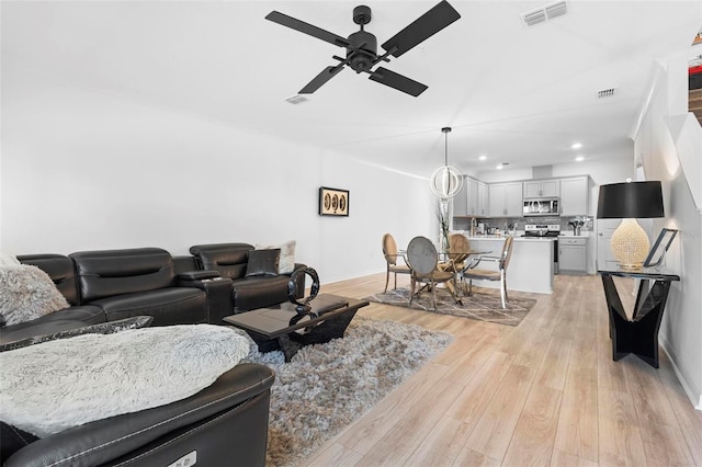 living room featuring ceiling fan and light wood-type flooring