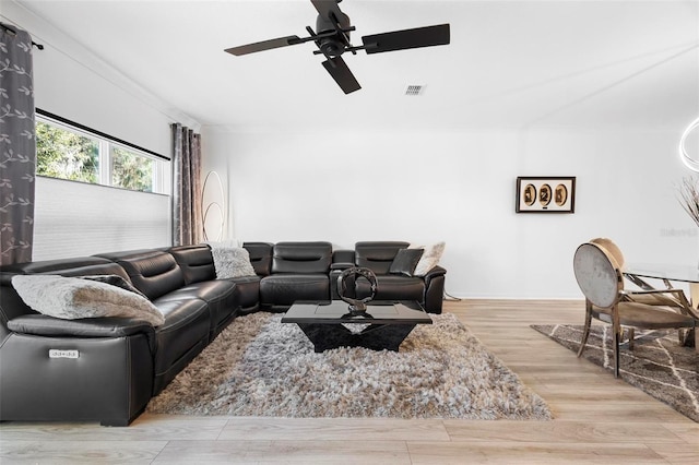 living room with ceiling fan, light hardwood / wood-style floors, and crown molding