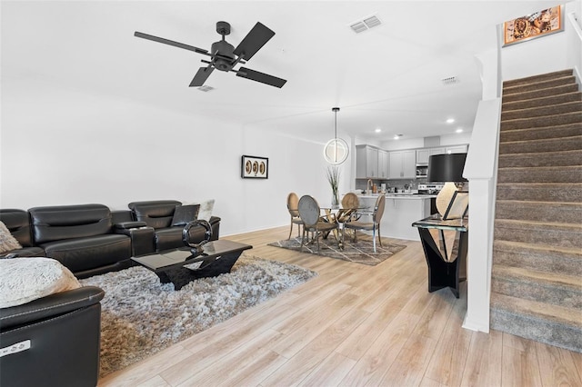 living room featuring light hardwood / wood-style flooring and ceiling fan