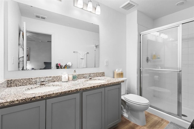 bathroom featuring vanity, hardwood / wood-style flooring, toilet, and walk in shower