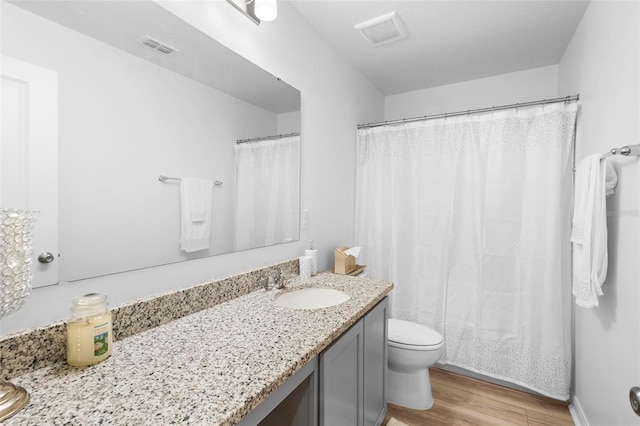 bathroom with hardwood / wood-style floors, vanity, and toilet