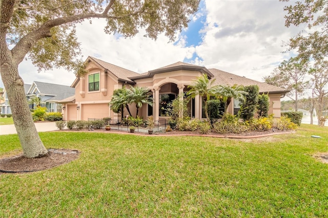 mediterranean / spanish house with a garage and a front lawn