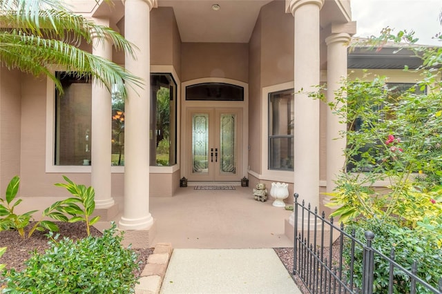 view of exterior entry with covered porch and french doors