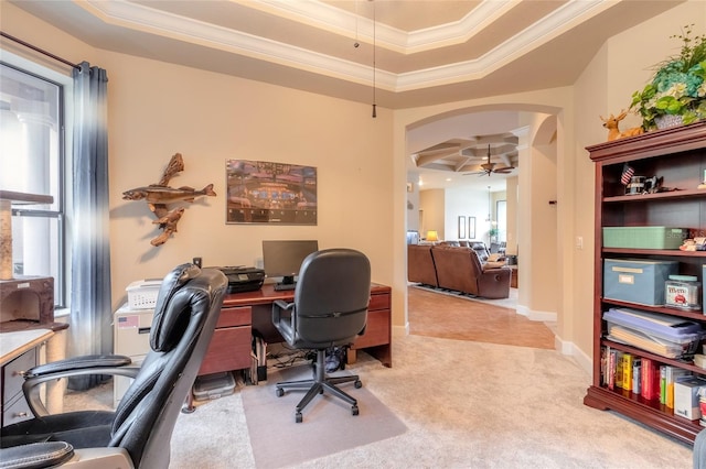 carpeted office space featuring a raised ceiling, ceiling fan, and ornamental molding