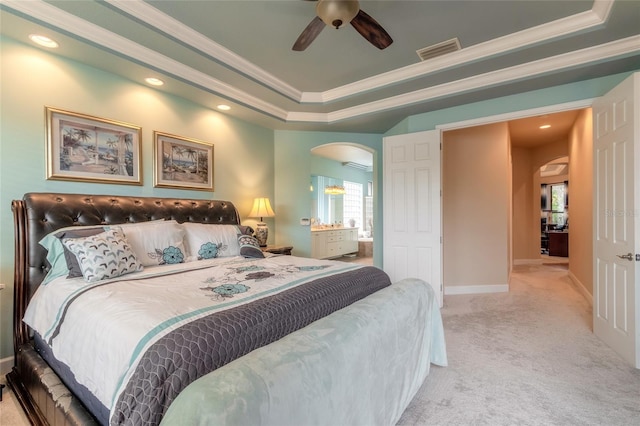 carpeted bedroom featuring a tray ceiling, ceiling fan, and crown molding