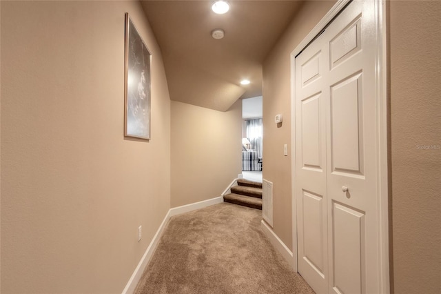 hallway with light carpet and lofted ceiling