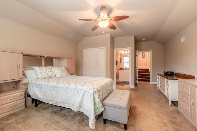 carpeted bedroom featuring ceiling fan, lofted ceiling, connected bathroom, and a closet