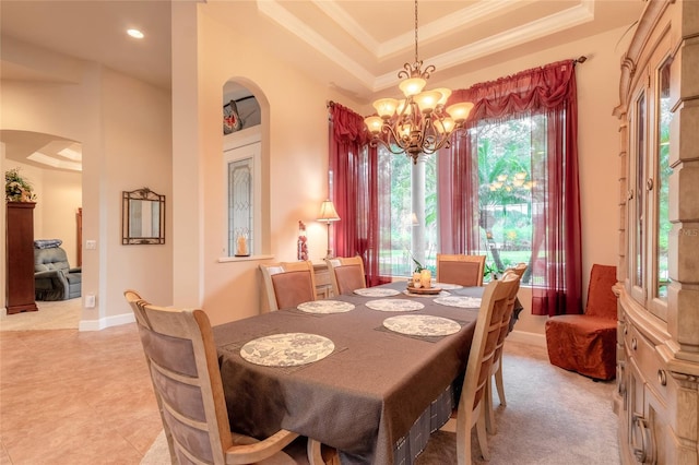 dining area featuring a raised ceiling, a notable chandelier, and crown molding