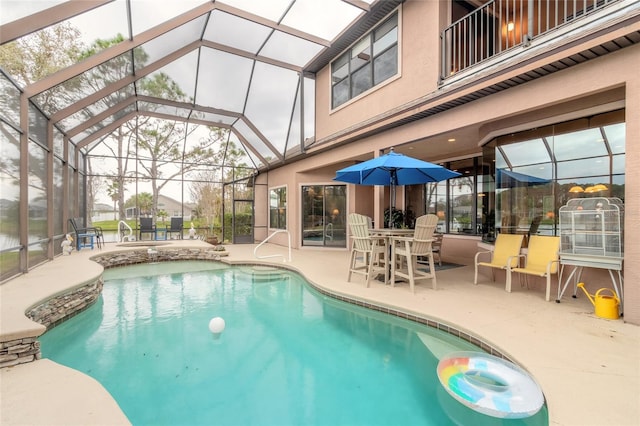 view of pool featuring glass enclosure and a patio area