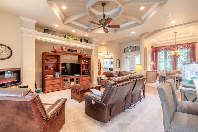 carpeted living room with french doors, ceiling fan with notable chandelier, ornamental molding, and coffered ceiling