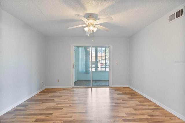 spare room with ceiling fan, light hardwood / wood-style floors, and a textured ceiling