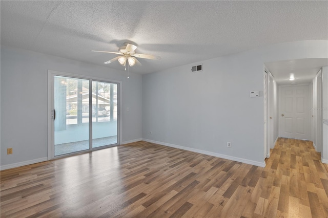 spare room with light wood-type flooring, ceiling fan, and a textured ceiling