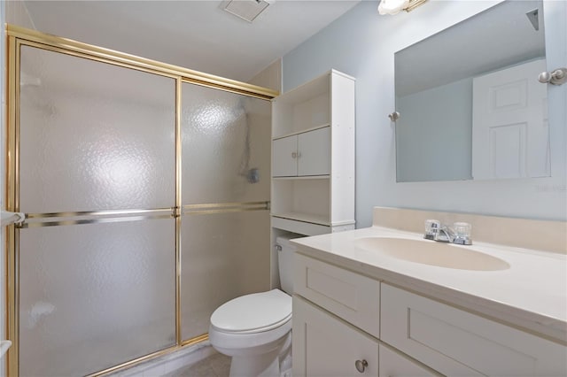 bathroom featuring vanity, a shower with shower door, and toilet