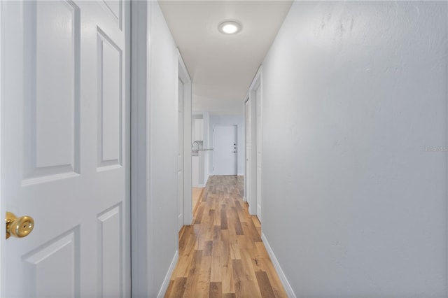 corridor with light hardwood / wood-style floors