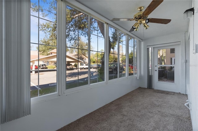 unfurnished sunroom featuring ceiling fan