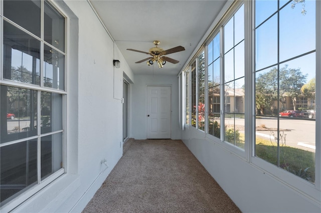 unfurnished sunroom featuring ceiling fan