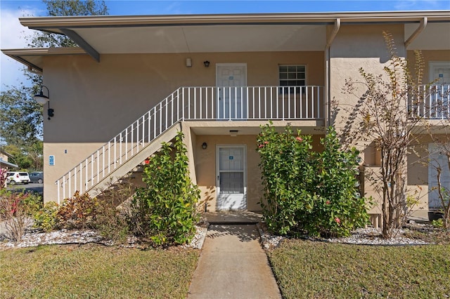 view of front of home featuring a front yard and a balcony