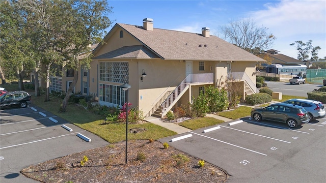 689 Wellington Station Blvd Unit 41, Ormond Beach, FL 32174 - view of property with stairs and uncovered parking