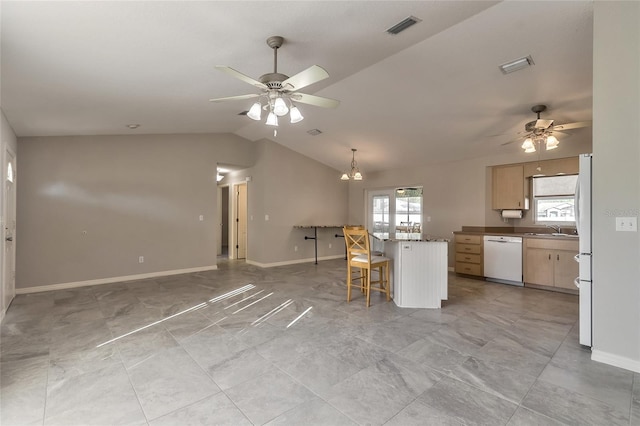 kitchen with light brown cabinets, vaulted ceiling, white appliances, a breakfast bar, and ceiling fan with notable chandelier