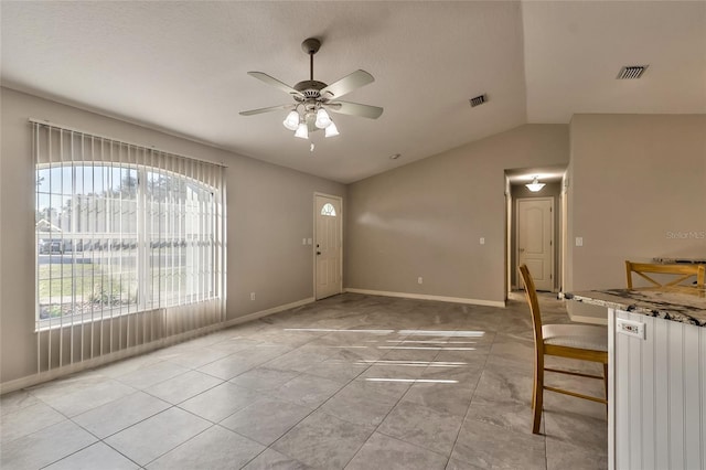 unfurnished dining area featuring light tile patterned floors, a wealth of natural light, lofted ceiling, and ceiling fan