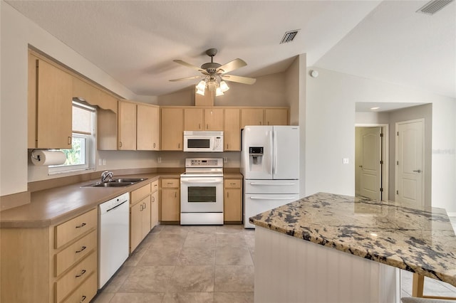 kitchen featuring white appliances, sink, light brown cabinetry, and vaulted ceiling