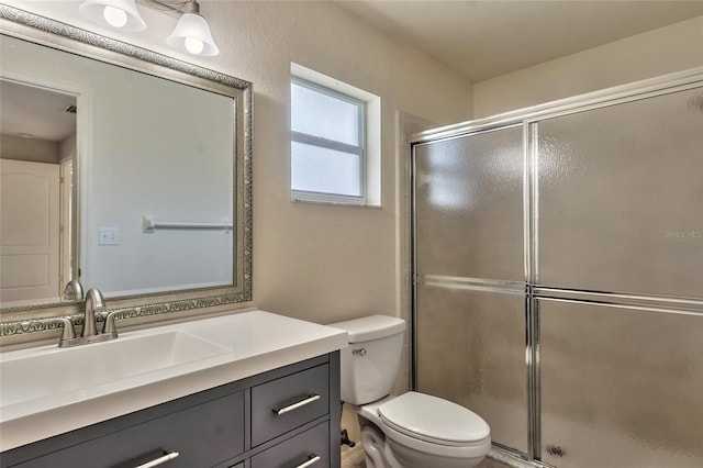 bathroom with vanity, toilet, and a shower with shower door