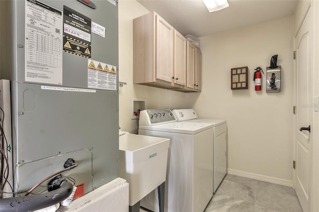 laundry area featuring washer and dryer, cabinets, sink, and heating unit