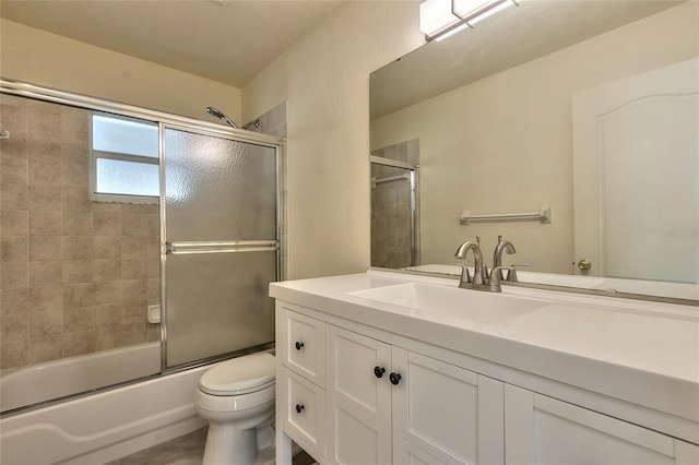 full bathroom featuring vanity, toilet, and shower / bath combination with glass door