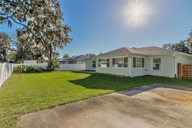 back of property with a lawn and a patio