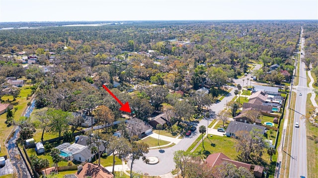 drone / aerial view featuring a wooded view and a residential view