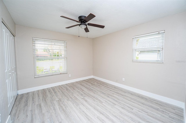 unfurnished room with a wealth of natural light, light wood-style flooring, and baseboards