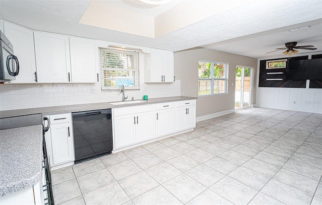 kitchen featuring a sink, black dishwasher, light countertops, a wealth of natural light, and decorative backsplash