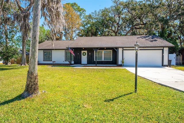 ranch-style house with driveway, an attached garage, and a front yard