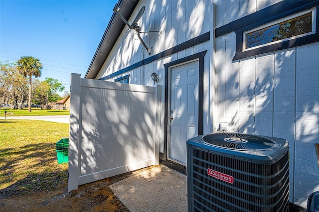 property entrance featuring a yard and central AC unit