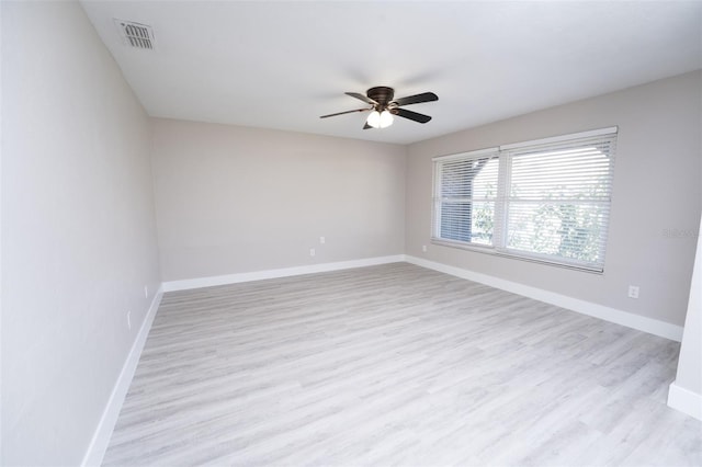 empty room with light wood-style floors, visible vents, ceiling fan, and baseboards