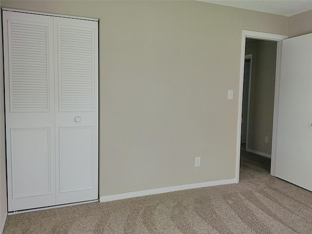 unfurnished bedroom featuring carpet flooring and a closet