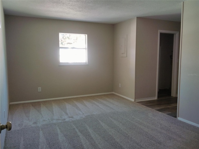 carpeted empty room with a textured ceiling