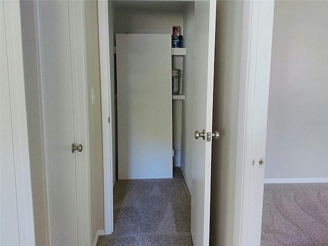 hall with dark colored carpet