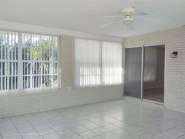 unfurnished room with ceiling fan and light tile patterned flooring