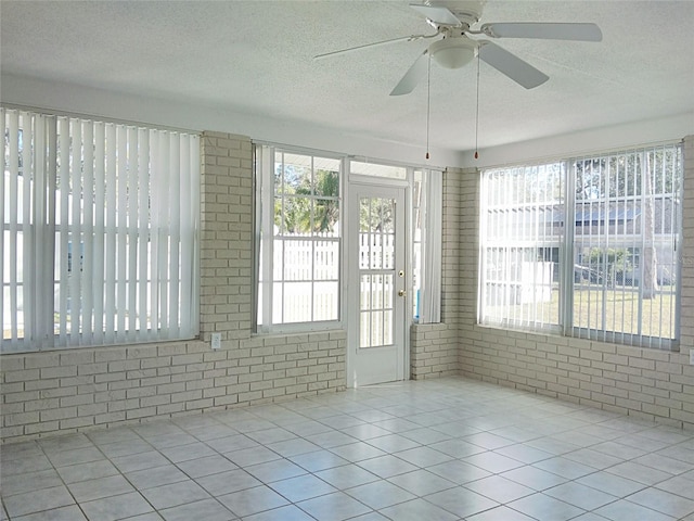 unfurnished sunroom featuring ceiling fan