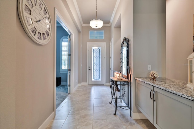 entryway with light tile patterned floors and ornamental molding