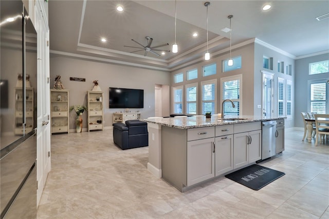 kitchen featuring a center island with sink, a raised ceiling, and sink