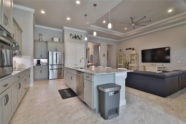 kitchen featuring gray cabinetry, stainless steel appliances, ceiling fan, sink, and an island with sink