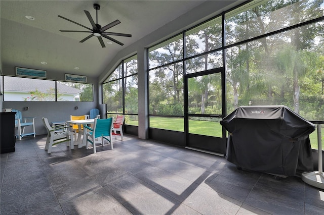 sunroom / solarium with ceiling fan and vaulted ceiling