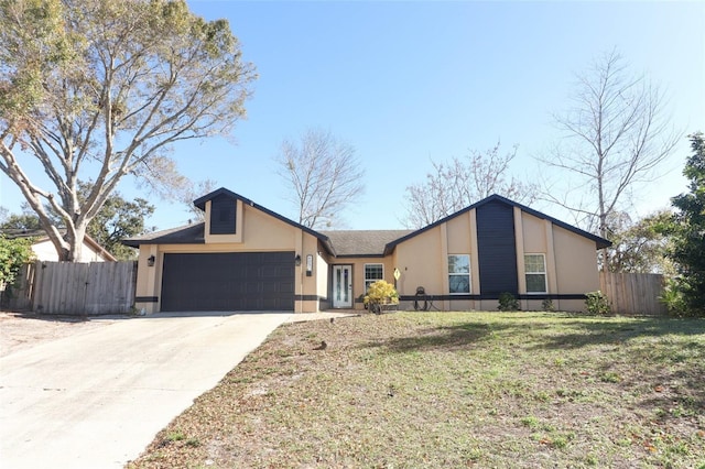 mid-century home with a garage, concrete driveway, fence, and stucco siding