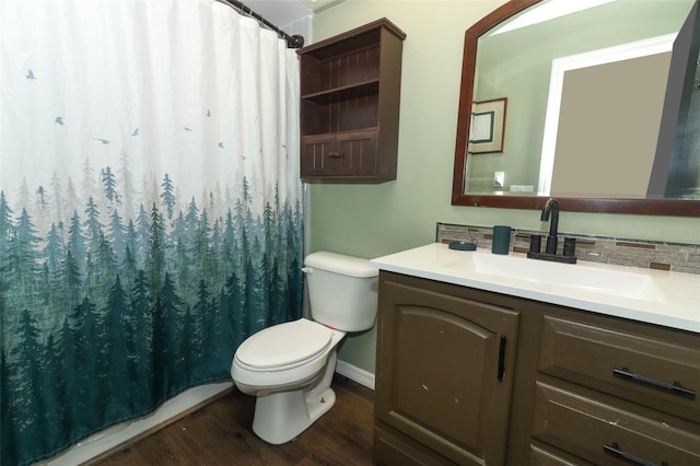 bathroom with toilet, wood finished floors, vanity, a shower with curtain, and tasteful backsplash