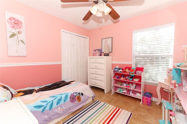 bedroom with a closet, ceiling fan, and tile patterned floors