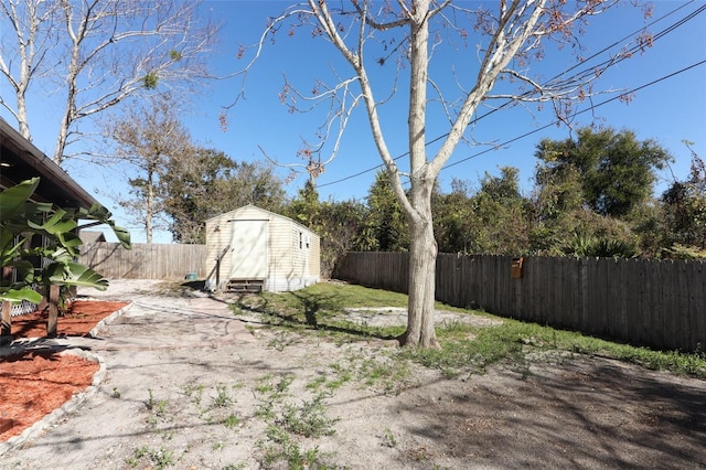 view of yard with a fenced backyard, a shed, and an outbuilding