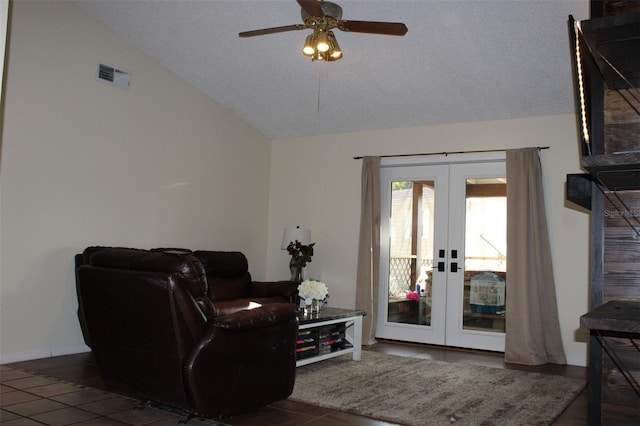 living area featuring a textured ceiling, visible vents, a ceiling fan, vaulted ceiling, and french doors