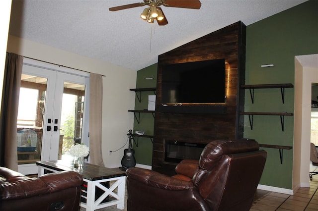 tiled living area with a large fireplace, french doors, vaulted ceiling, and a textured ceiling